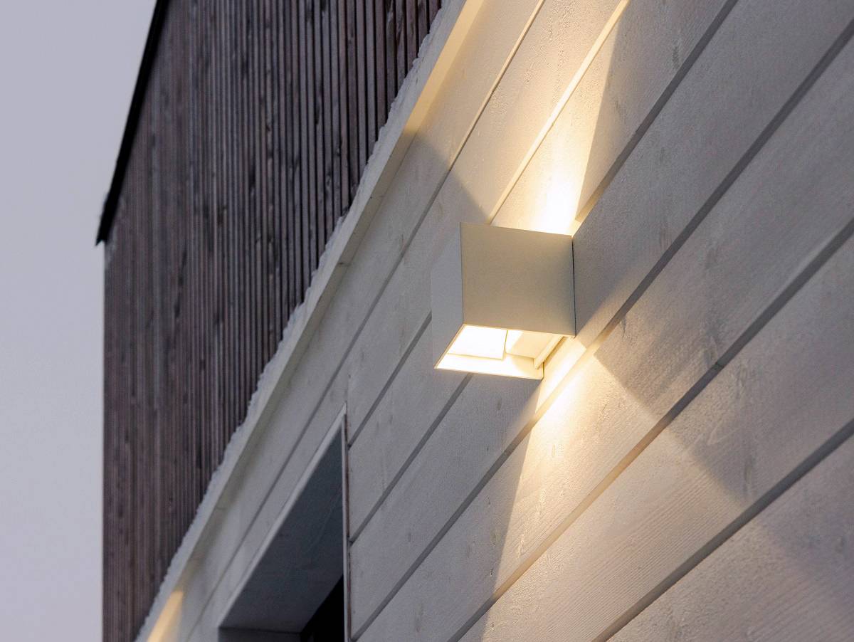 Gros plan d'une applique FUNK blanche sur un mur extérieur.